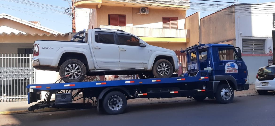 Guincho Pereira transportando picape branca em frente a residência